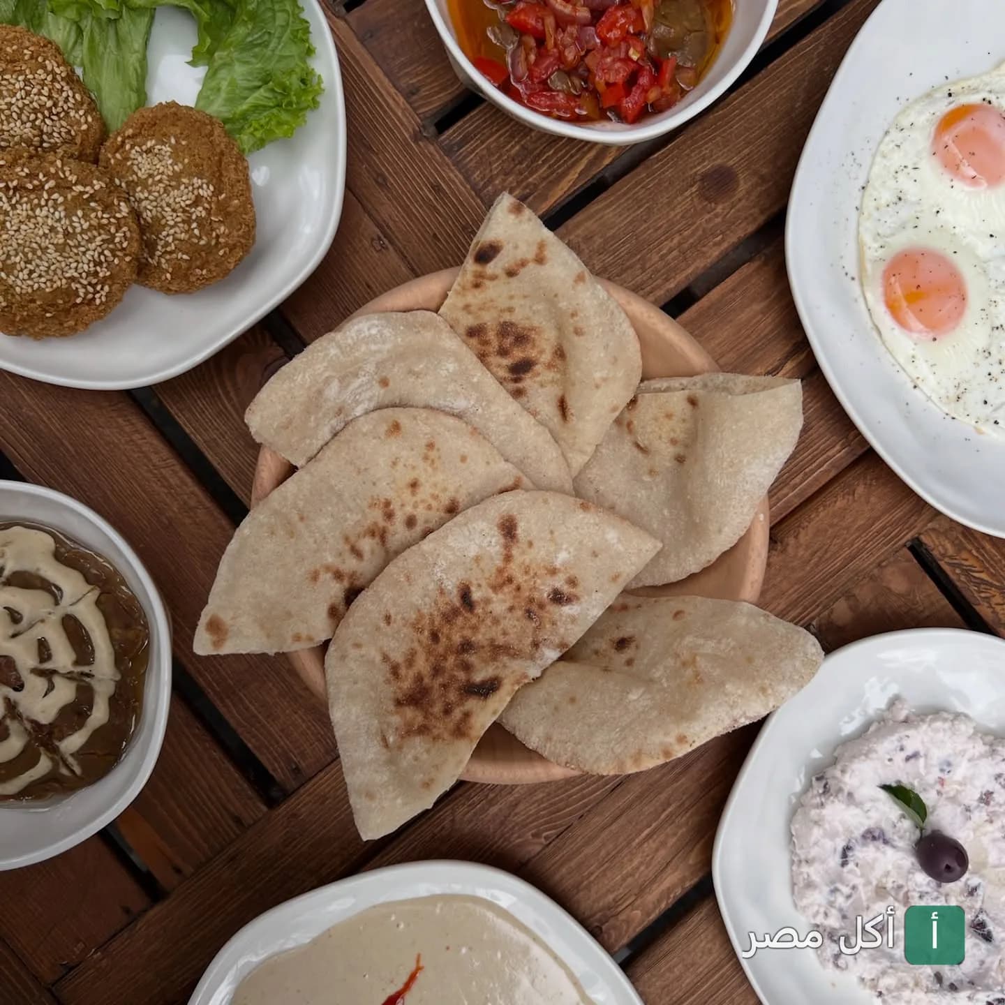 سفرة فطور مصري متنوعة تضم طعمية وبيض وخبز في شاتز سوشيال هاوس بألماظة