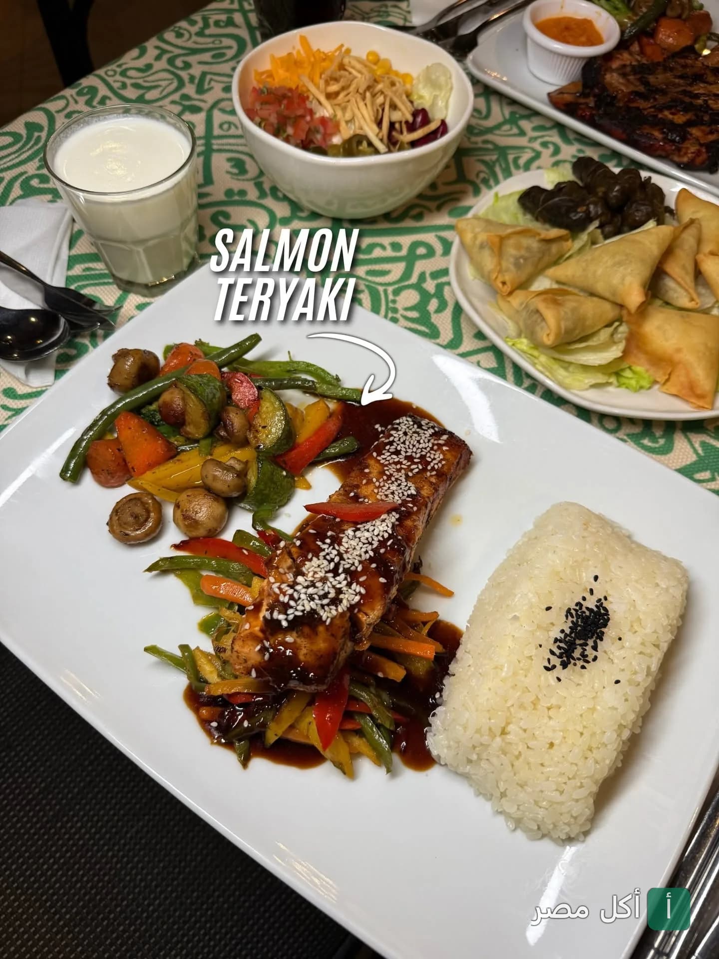 طبق سلمون ترياكي مع خضار سوتيه وأرز في شاتز سوشيال هاوس بألماظة.