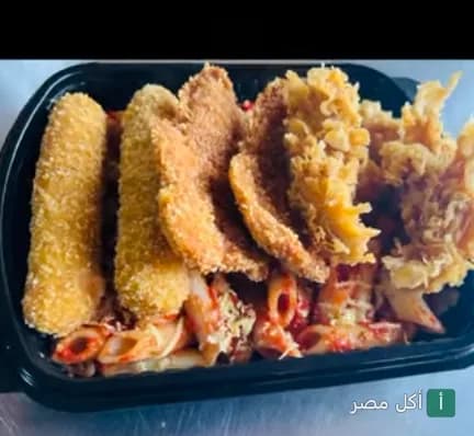 طبق مكرونة بصلصة الطماطم مع قطع دجاج مقرمشة في مطعم مارتيني شيف بمصر الجديدة.