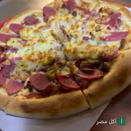 بيتزا بالسجق والزيتون من مطعم مارتيني شيف في مصر الجديدة.