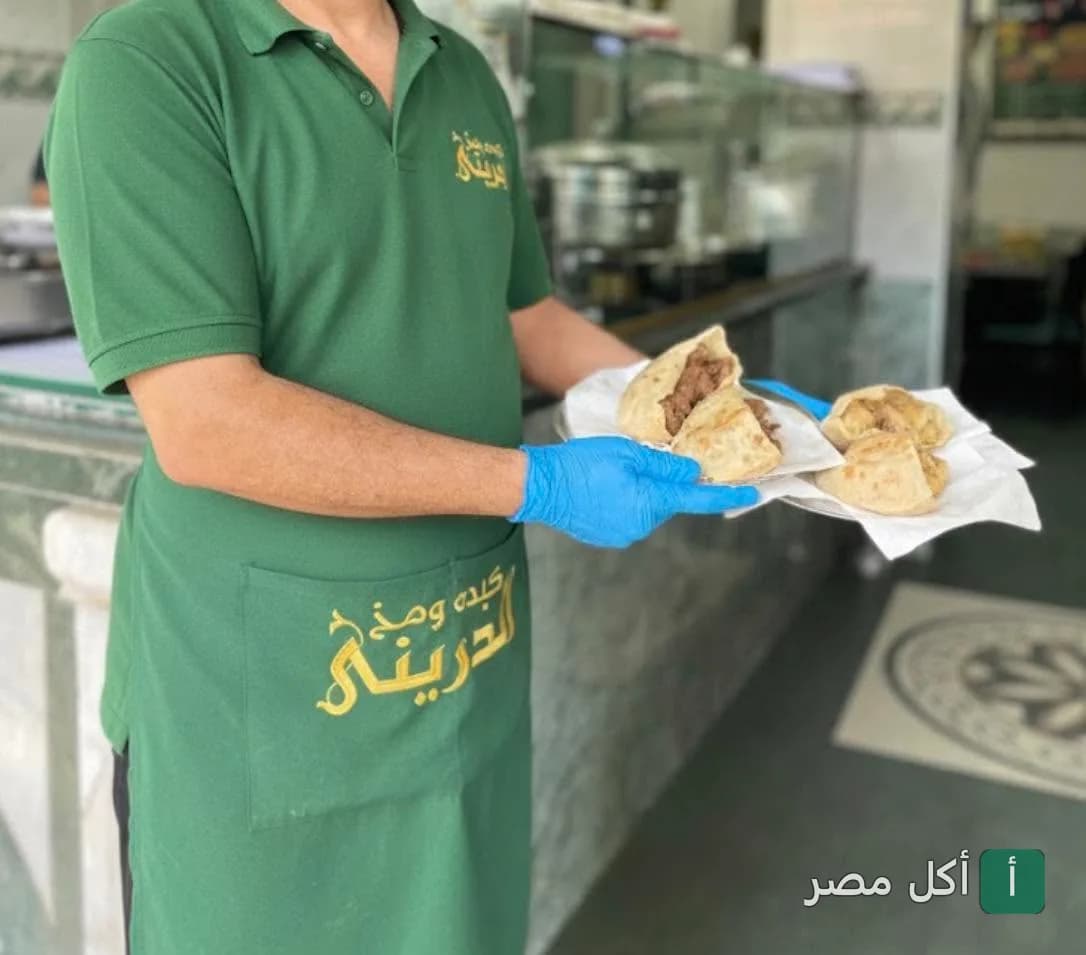 موظف في مطعم كبده ومخ الدريني بجزيرة إمبابة يقدم سندوتشات الكبدة والمخ في خبز بلدي.
