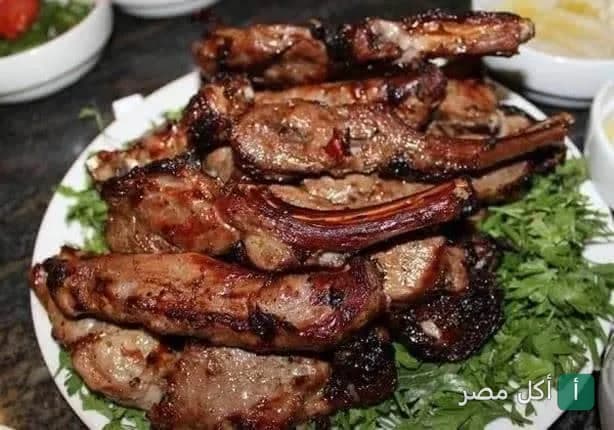 طبق ريش ضاني مشوية على الفحم مقدمة على فرشة بقدونس في مطعم حاتي الوحدة بإمبابة.