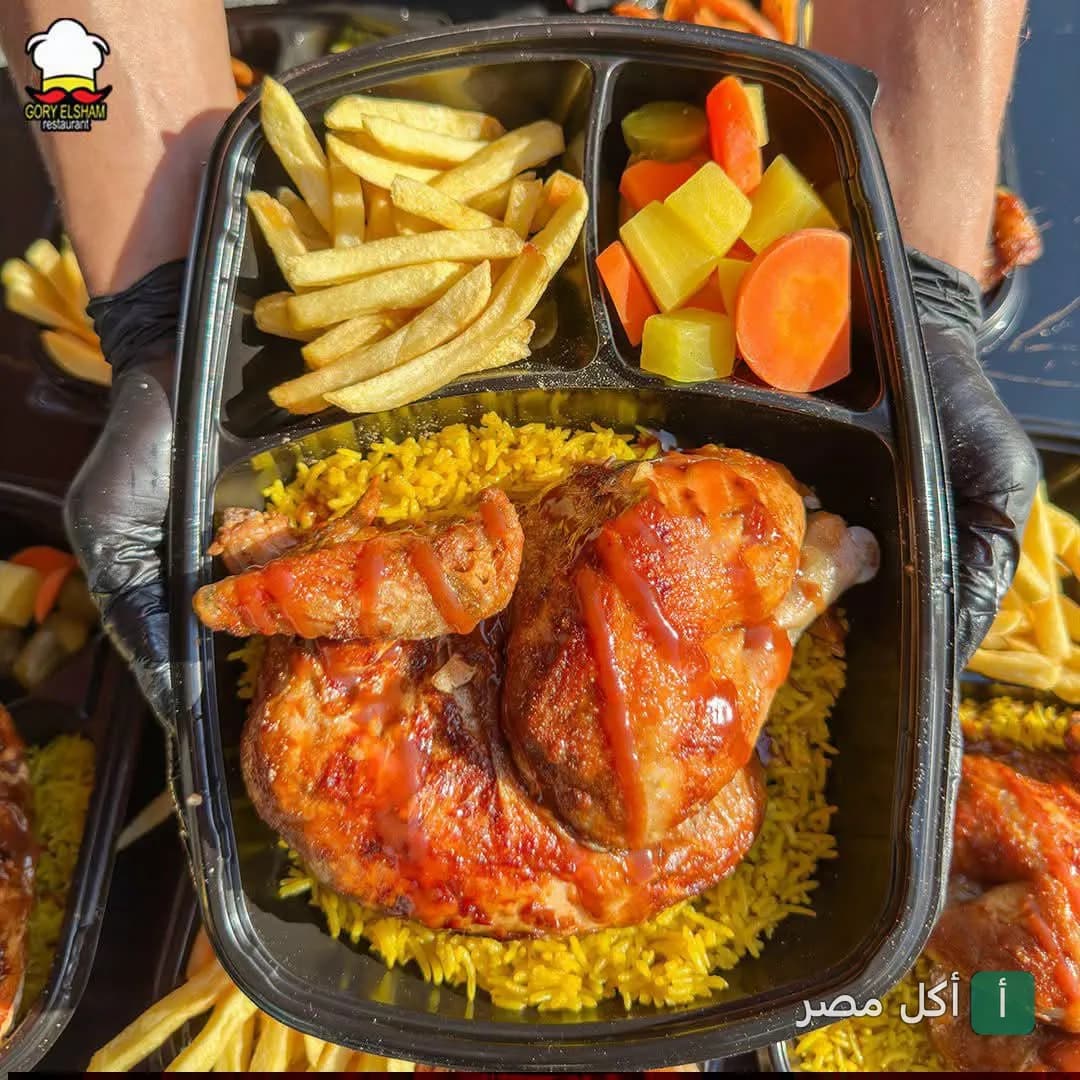 وجبة دجاج مشوي مع أرز أصفر وبطاطس مخلل في علبة تقديم من مطعم جوري الشام بإمبابة.