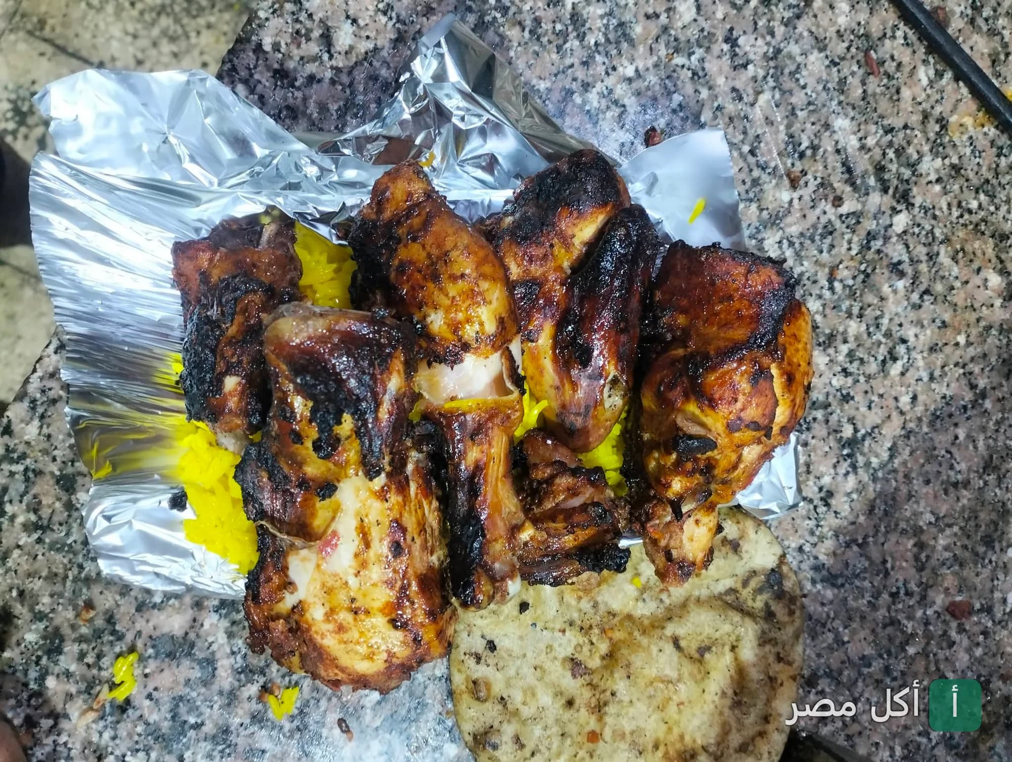 قطع دجاج مشوي على الفحم مع أرز أصفر في كبابجي أبو غنيمة بإمبابة