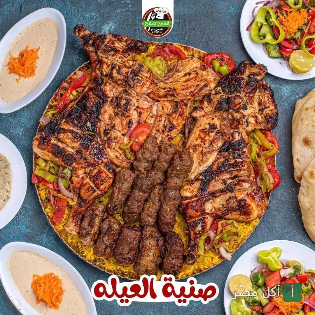 صينية مشويات كبيرة تضم دجاج مشوي وكفتة من مطعم الشيخ صلاح الكبابجي في إمبابة مع سلطات وطحينة.