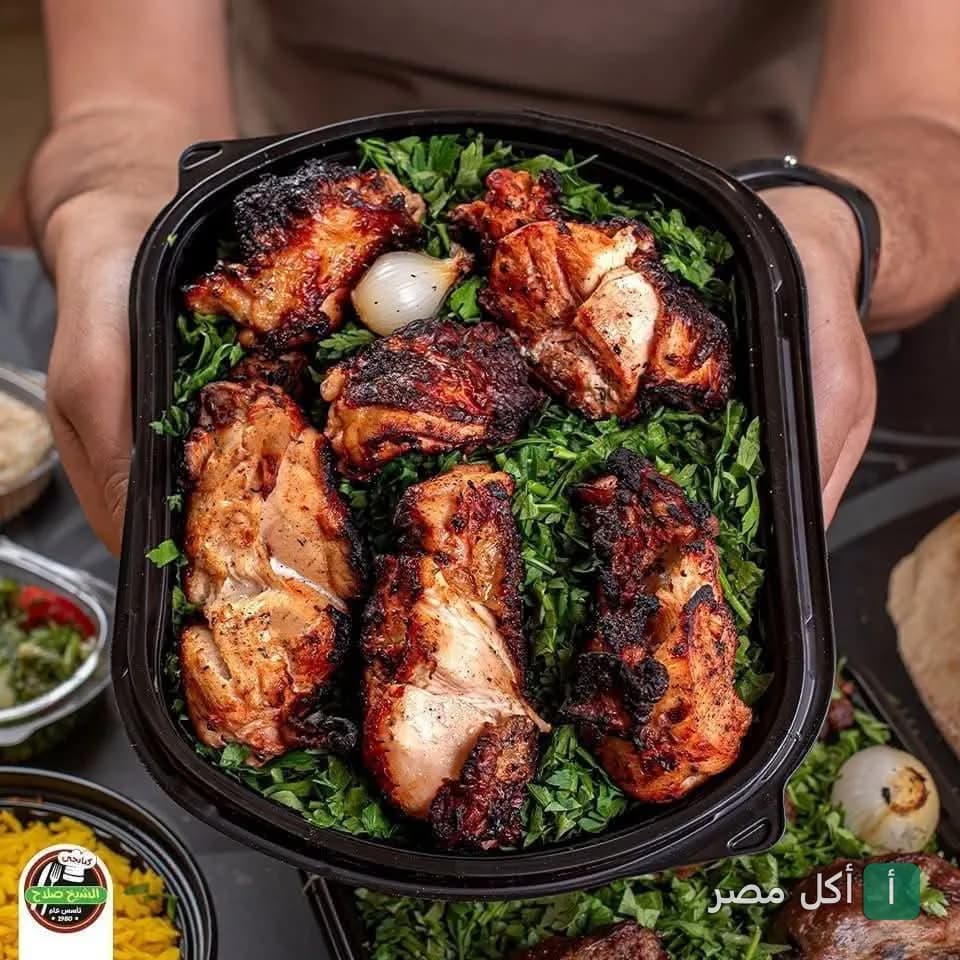 طبق مشويات دجاج مشوي على الفحم مع البقدونس من مطعم الشيخ صلاح الكبابجي في إمبابة.