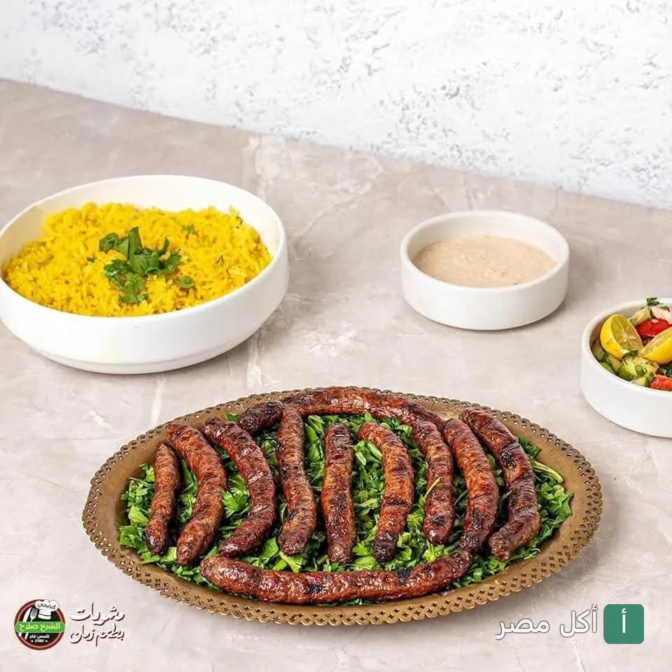 طبق مشويات من مطعم الشيخ صلاح الكبابجي في إمبابة مع أرز أصفر وسلطة وطحينة.