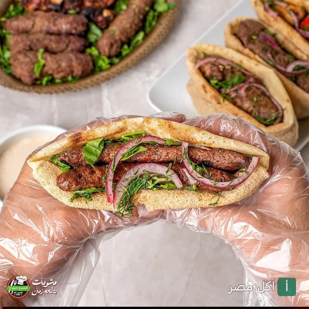 ساندوتش كفتة مشوية في خبز بلدي مع البصل والبقدونس من مطعم الشيخ صلاح الكبابجي في إمبابة.