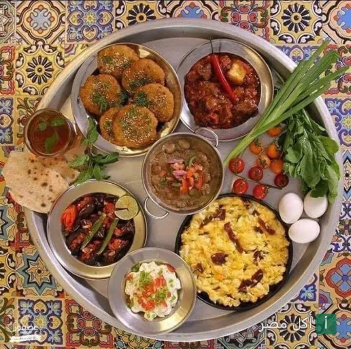 صينية فطور مصري تقليدي متنوعة من مطعم الشبراوي في جزيرة إمبابة، تضم الفول والطعمية والبيض والجبن.