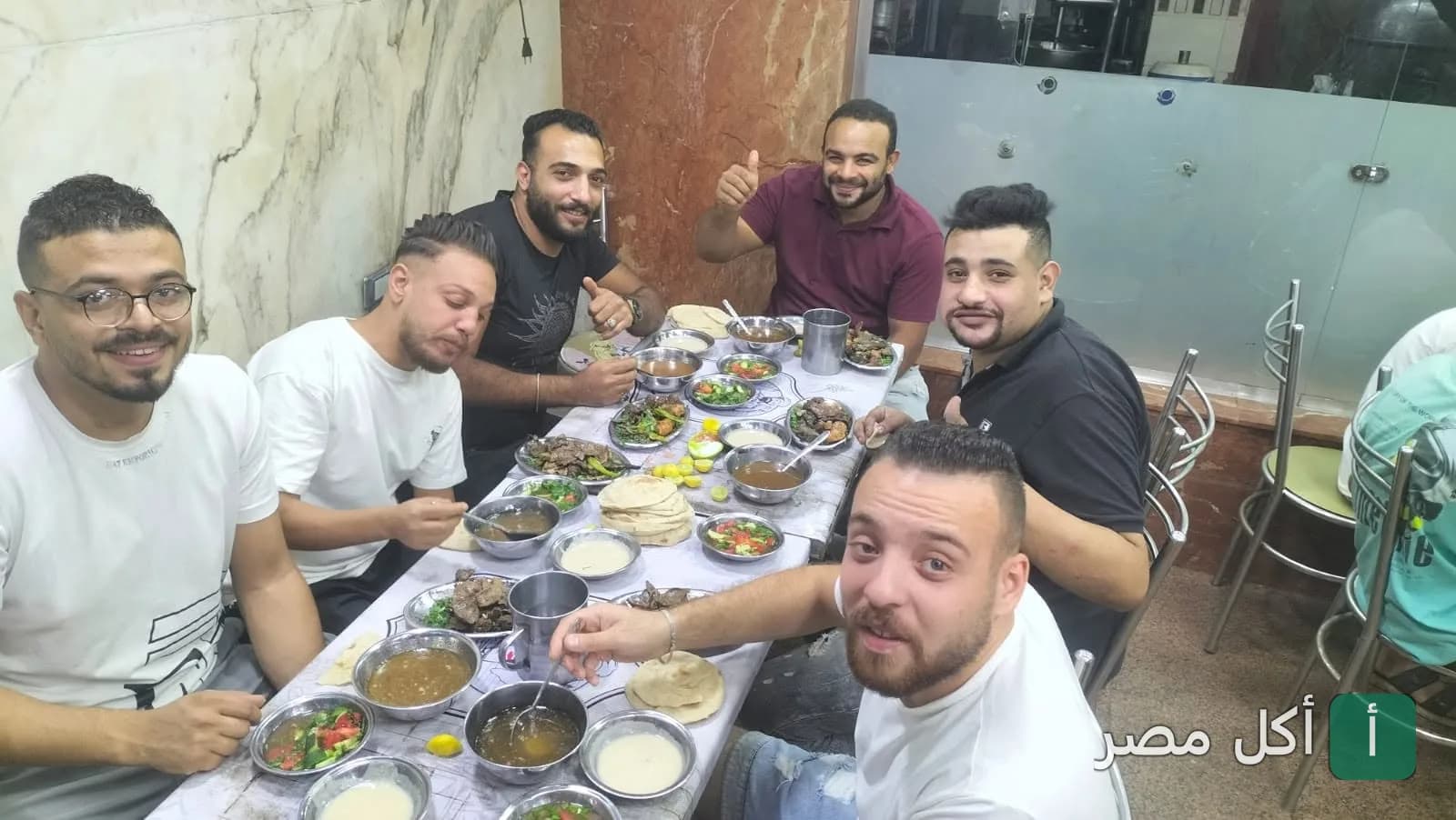 مجموعة من الأصدقاء يتناولون الطعام في مطعم عكوه بجزيرة إمبابة.