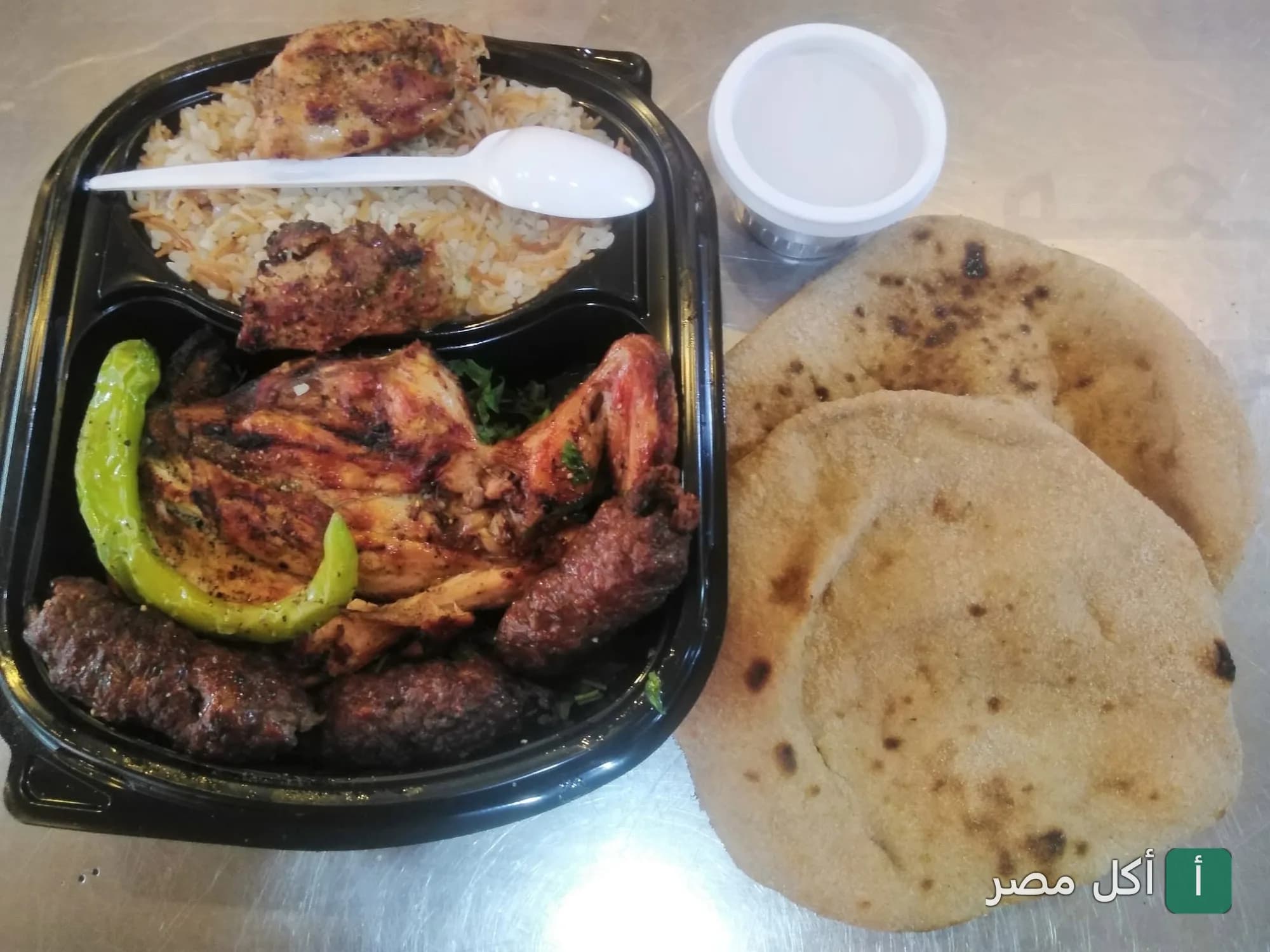 وجبة مشويات شرقية من مطعم رخا بإمبابة، تتكون من دجاج مشوي وكفتة مع أرز وخبز بلدي.
