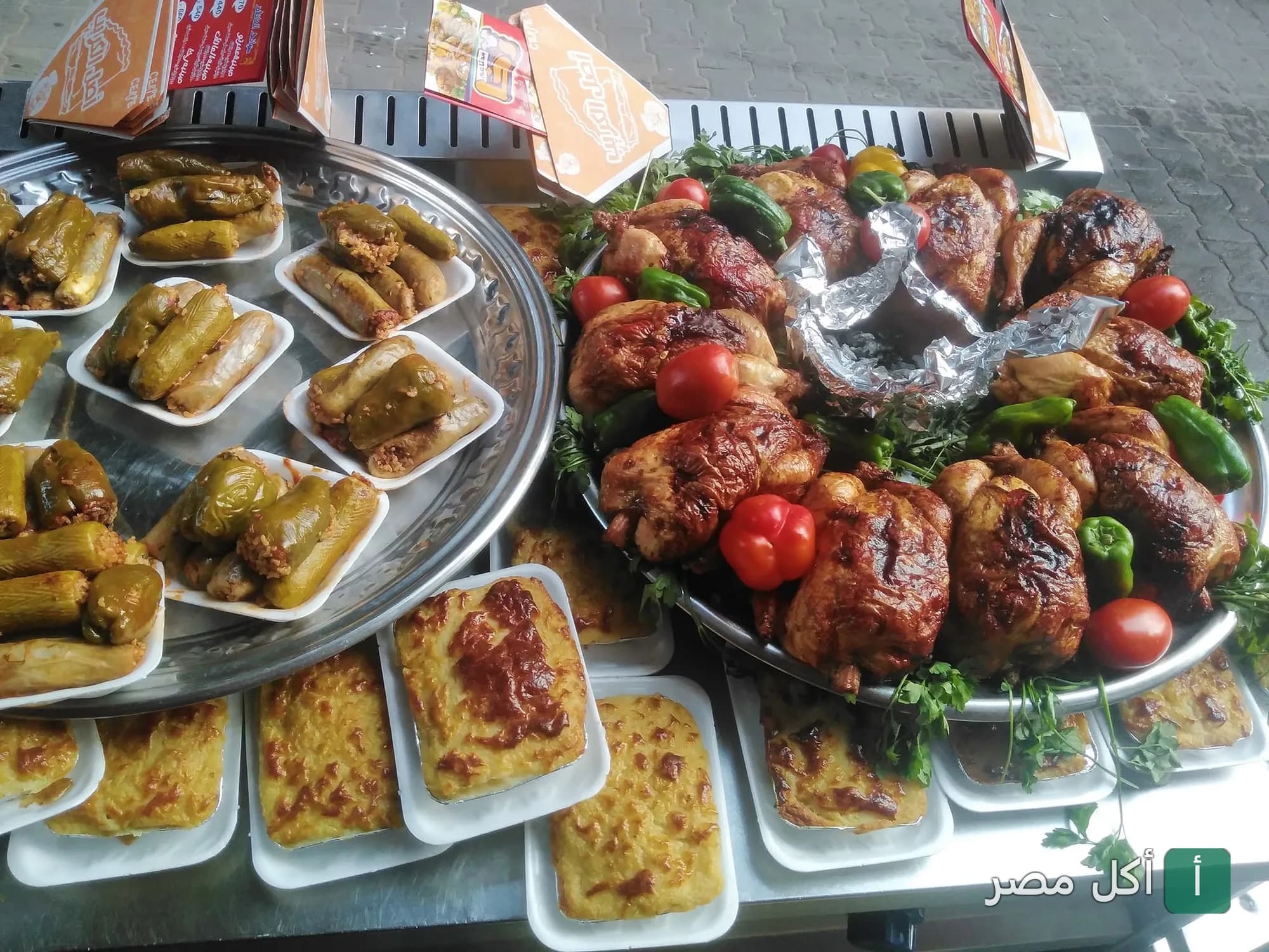 صينية كبيرة عليها دجاج مشوي ومحشي ورق عنب وكوسة ومكرونة بالبشاميل في مطعم رخا بإمبابة.