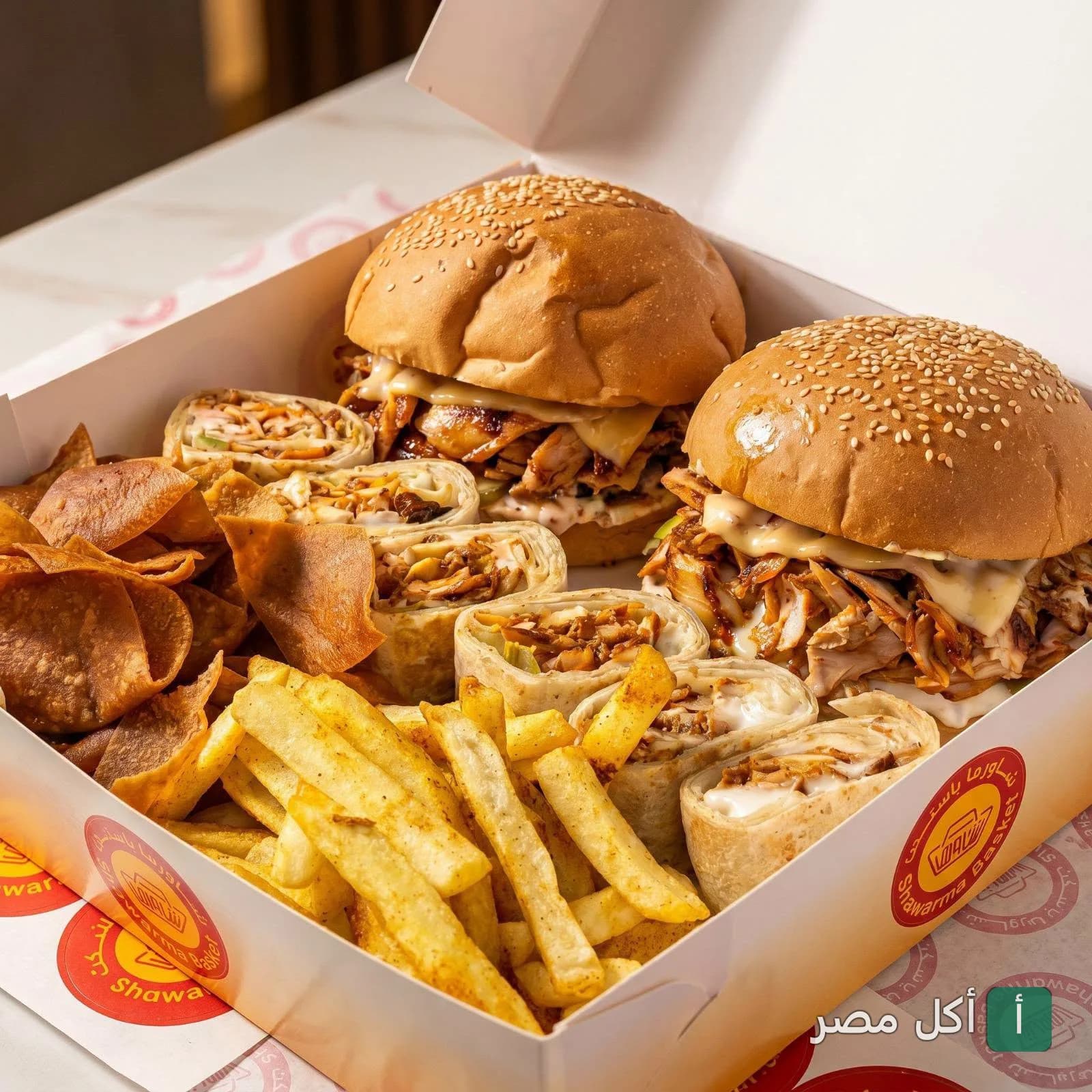 وجبة شاورما باسكت في إمبابة تحتوي على ساندوتشات شاورما برجر، رولات شاورما، بطاطس مقلية ورقائق خبز مقرمشة.