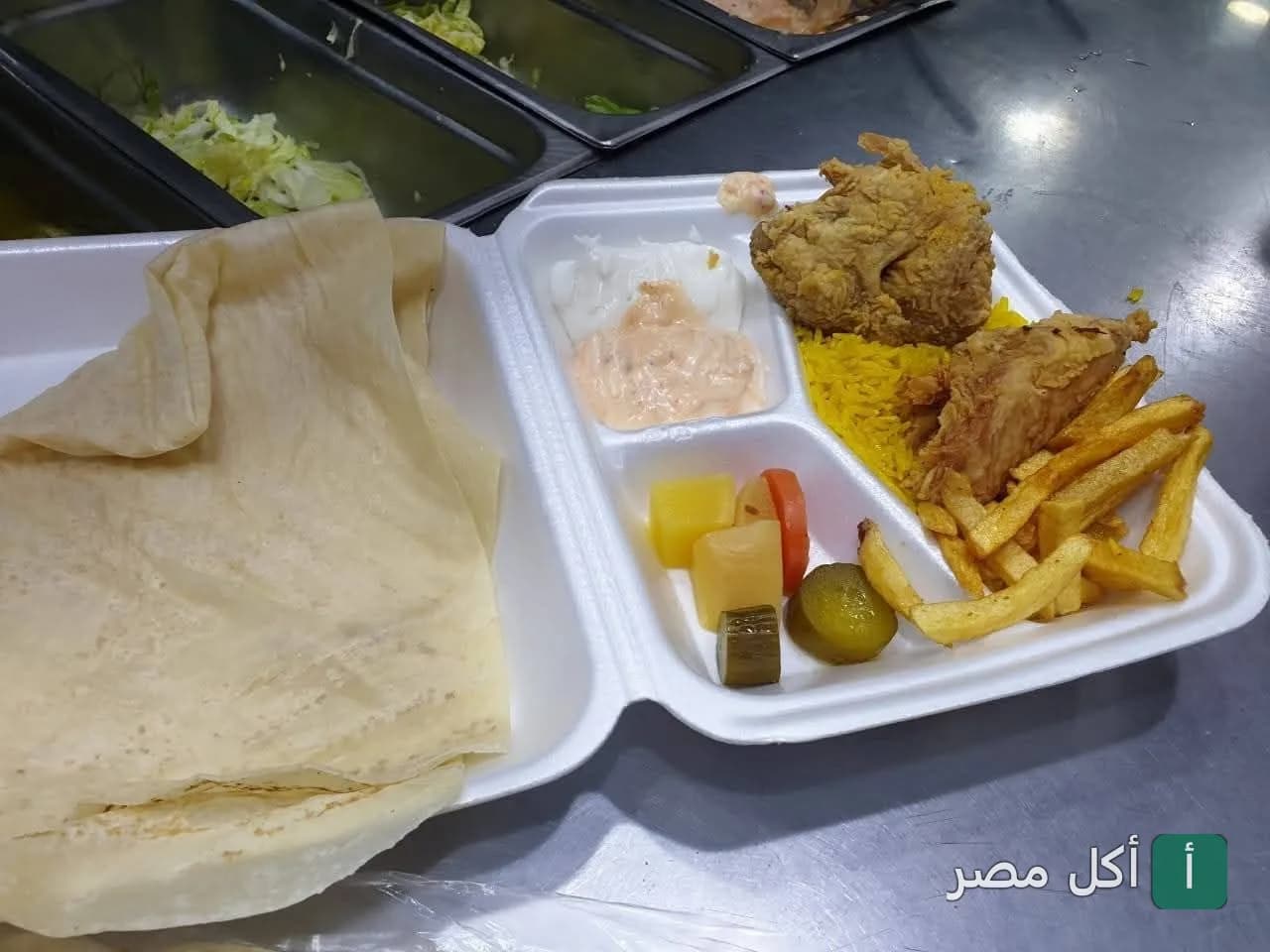 وجبة دجاج مقلي مع أرز أصفر وبطاطس ومخلل في مطعم التاج السوري بإمبابة