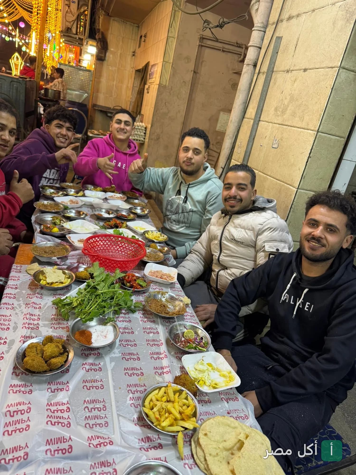 مجموعة من الشباب يتناولون وجبة إفطار شرقية متنوعة في مطعم فول وفلافل نيو ومبى بجزيرة إمبابة.