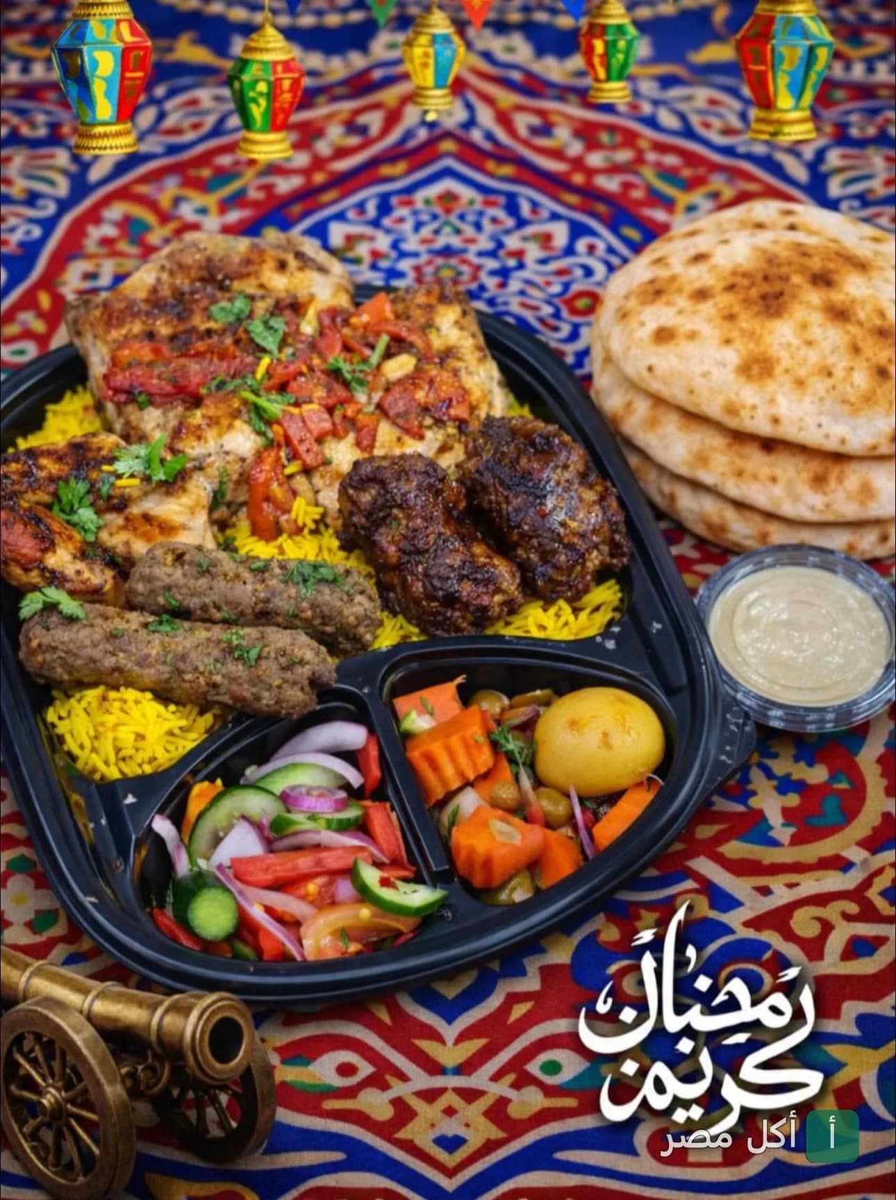 طبق مشاوي مشكل من مطعم أبو خديجة في إمبابة مع أرز وخضار ومقبلات على مفرش رمضاني.