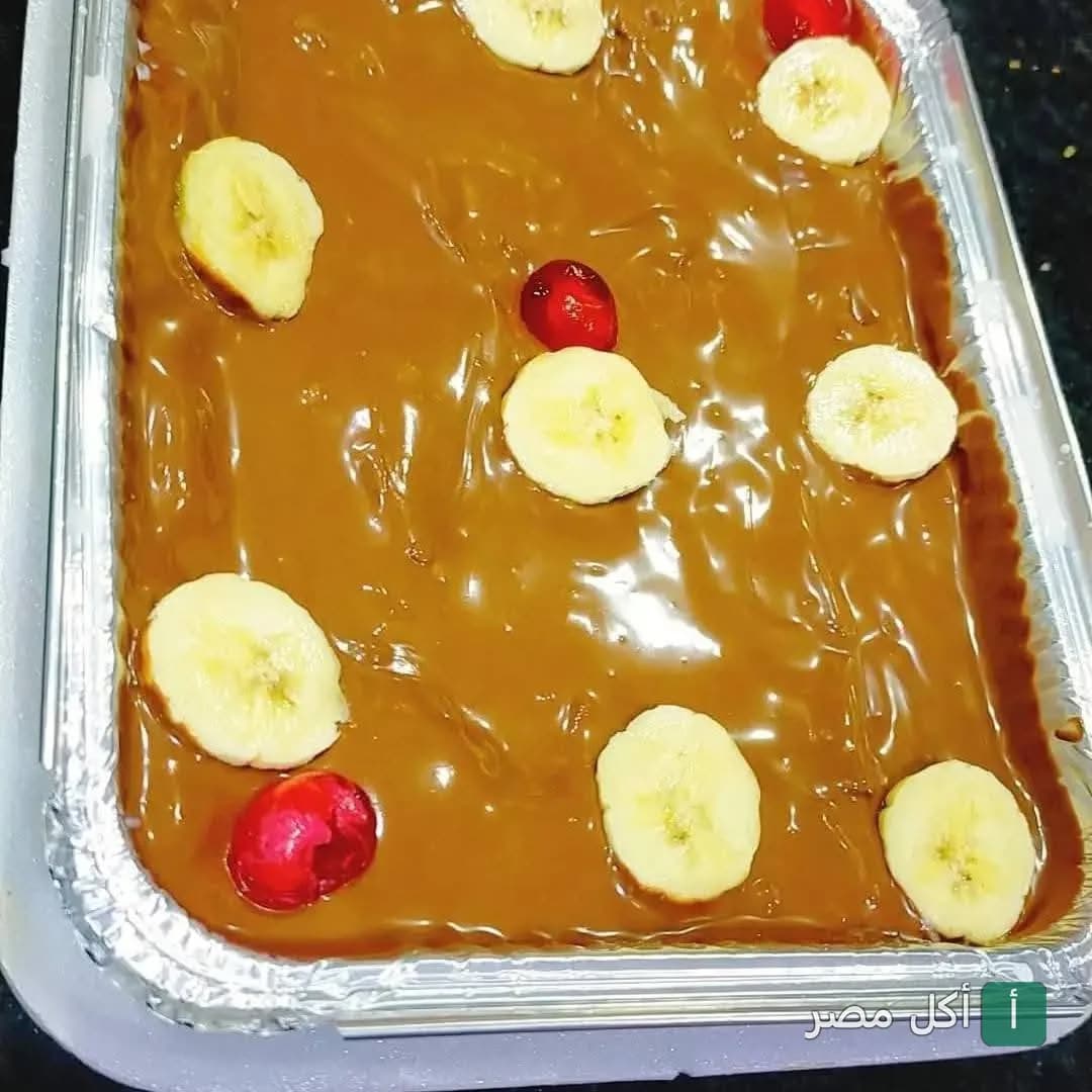 صينية حلوى مغطاة بصوص الكراميل وشرائح الموز والكرز من بيتزا الرحاب في إمبابة.