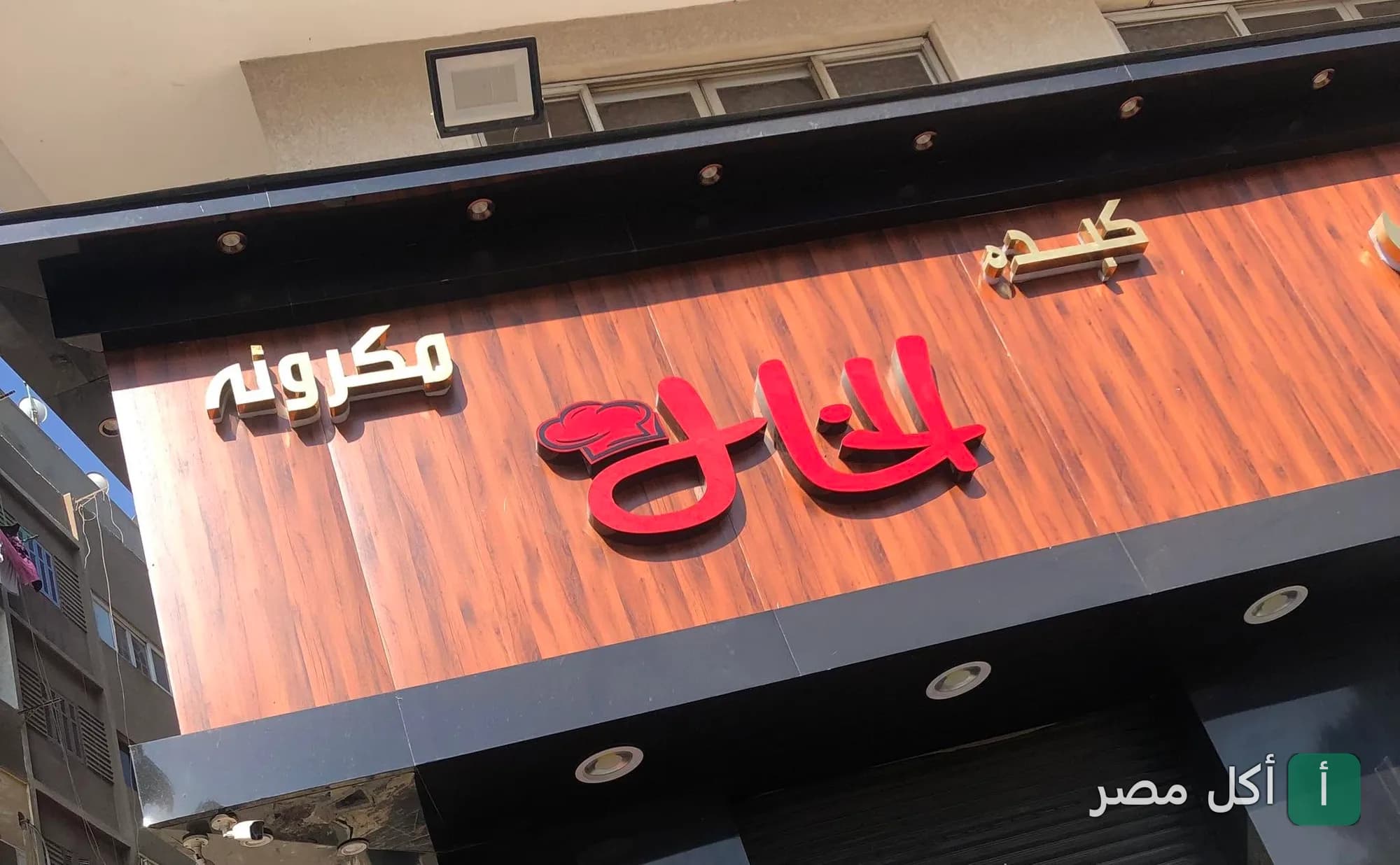 واجهة مطعم الخال في جزيرة إمبابة بالجيزة، تظهر لافتة المطعم الخشبية باللونين الأحمر والأسود.