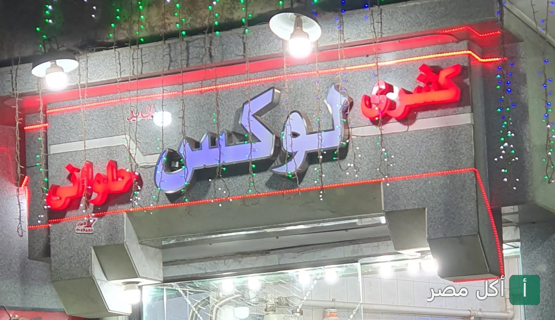 واجهة مطعم كشري لوكس في المنيرة بإمبابة مع لافتة مضيئة بالنيون