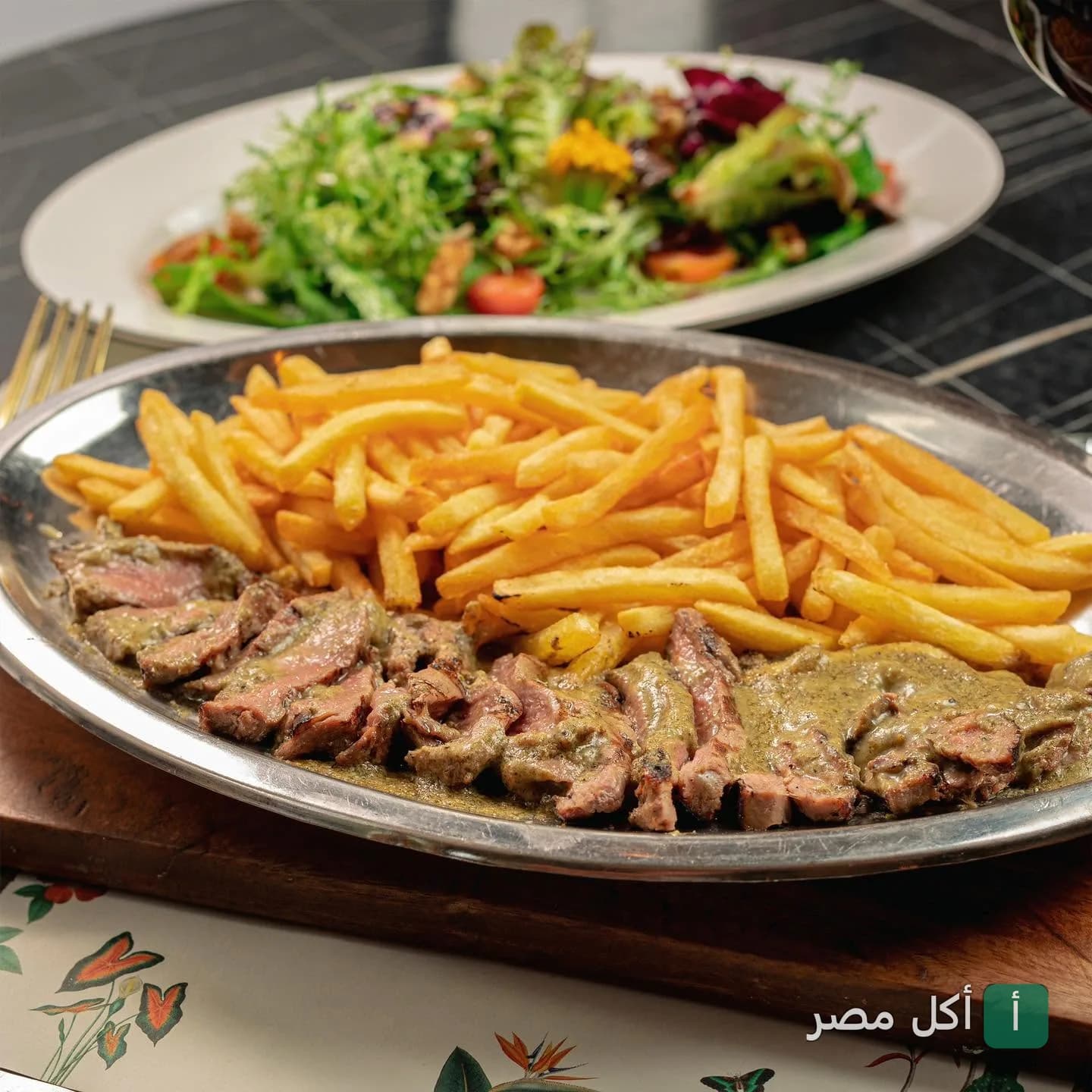 طبق ستيك مع صوص و بطاطس مقلية بجانبه طبق سلطة في مطعم ميزون دو باري بالشيخ زايد