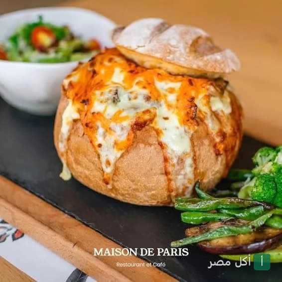 وجبة مقدمة داخل خبز محشو بالجبن الذائب مع طبق جانبي من الخضار في مطعم ميزون دي باريس بالشيخ زايد.
