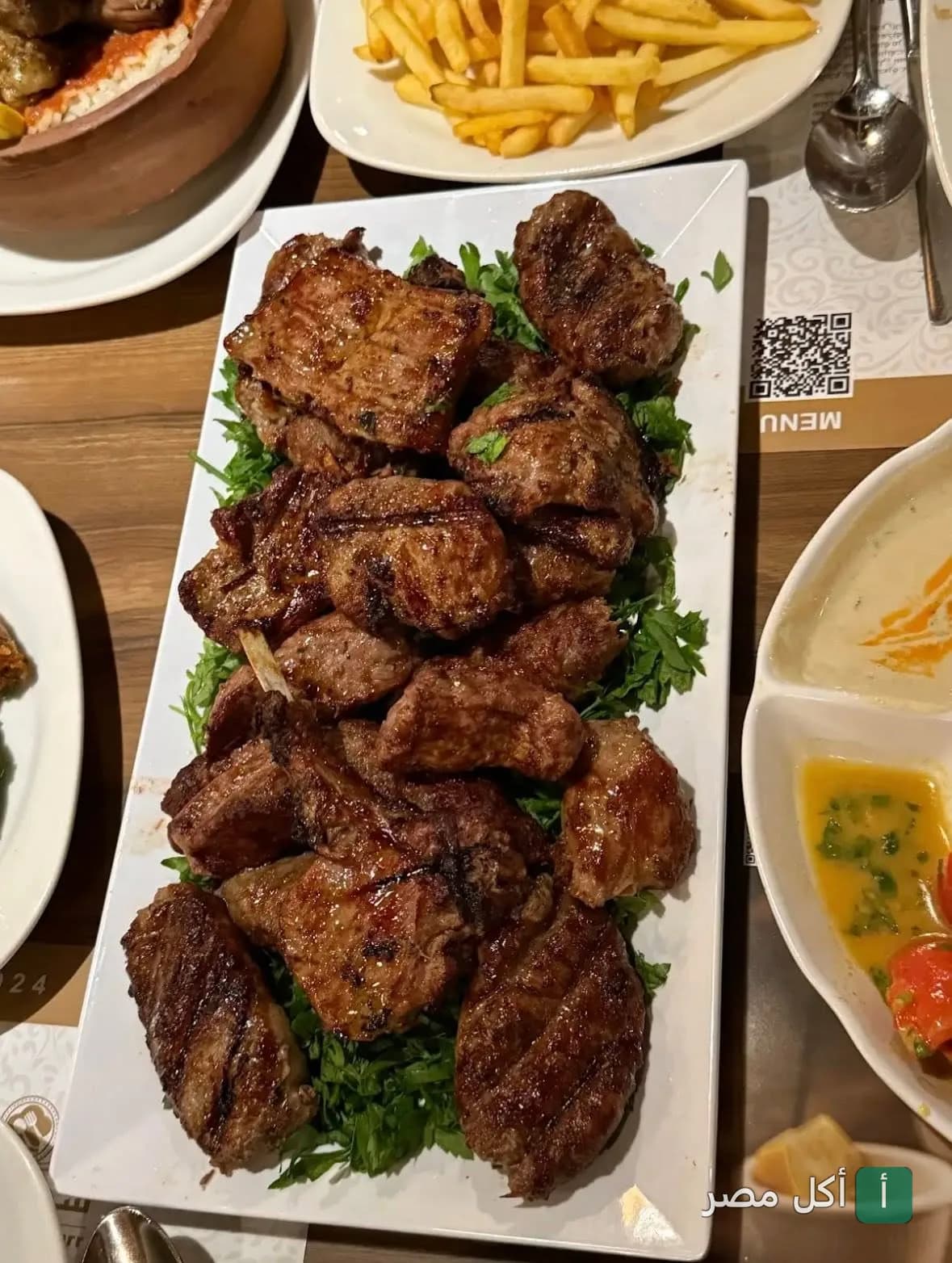 طبق مشاوي مشكلة من مطعم شجرة الدر في الشيخ زايد، يقدم على فرشة من البقدونس.