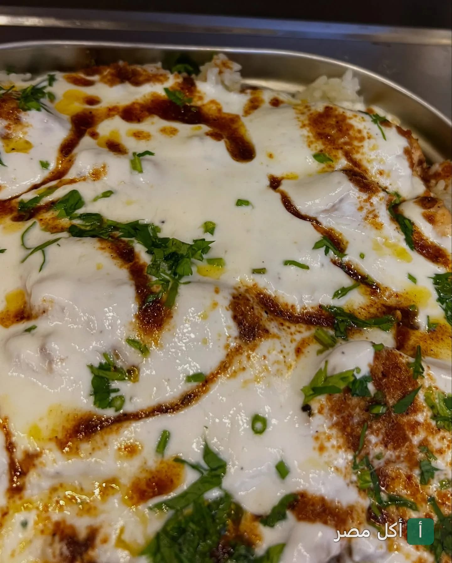طبق فتة مغطى بصوص الزبادي والتقلية والبقدونس في مطعم ديلوكا بالشيخ زايد.