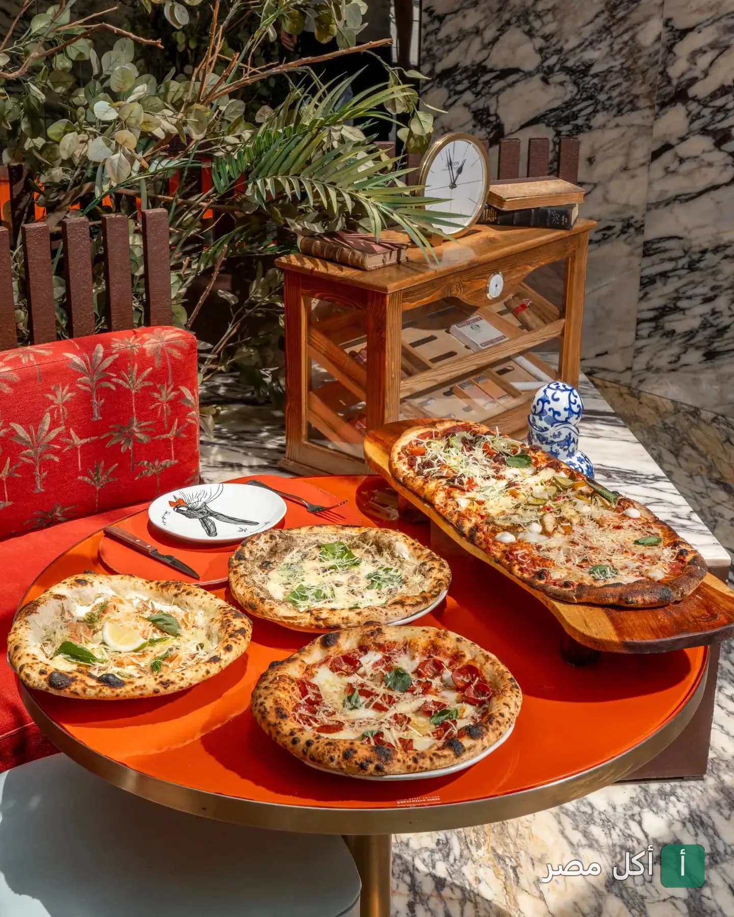 تشكيلة متنوعة من البيتزا الإيطالية على طاولة مستديرة في مطعم Maze Roofresto بالشيخ زايد.