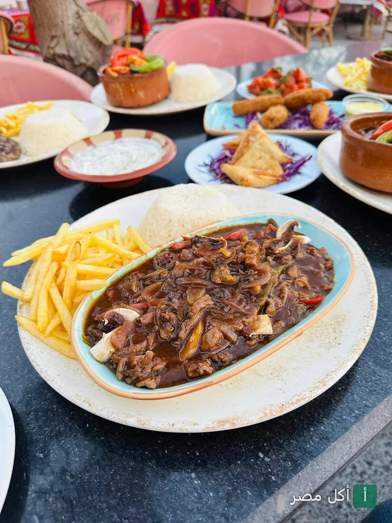 مائدة متنوعة من الأطباق الشرقية والمشويات مع الأرز والبطاطس في مطعم فلوري بالشيخ زايد.