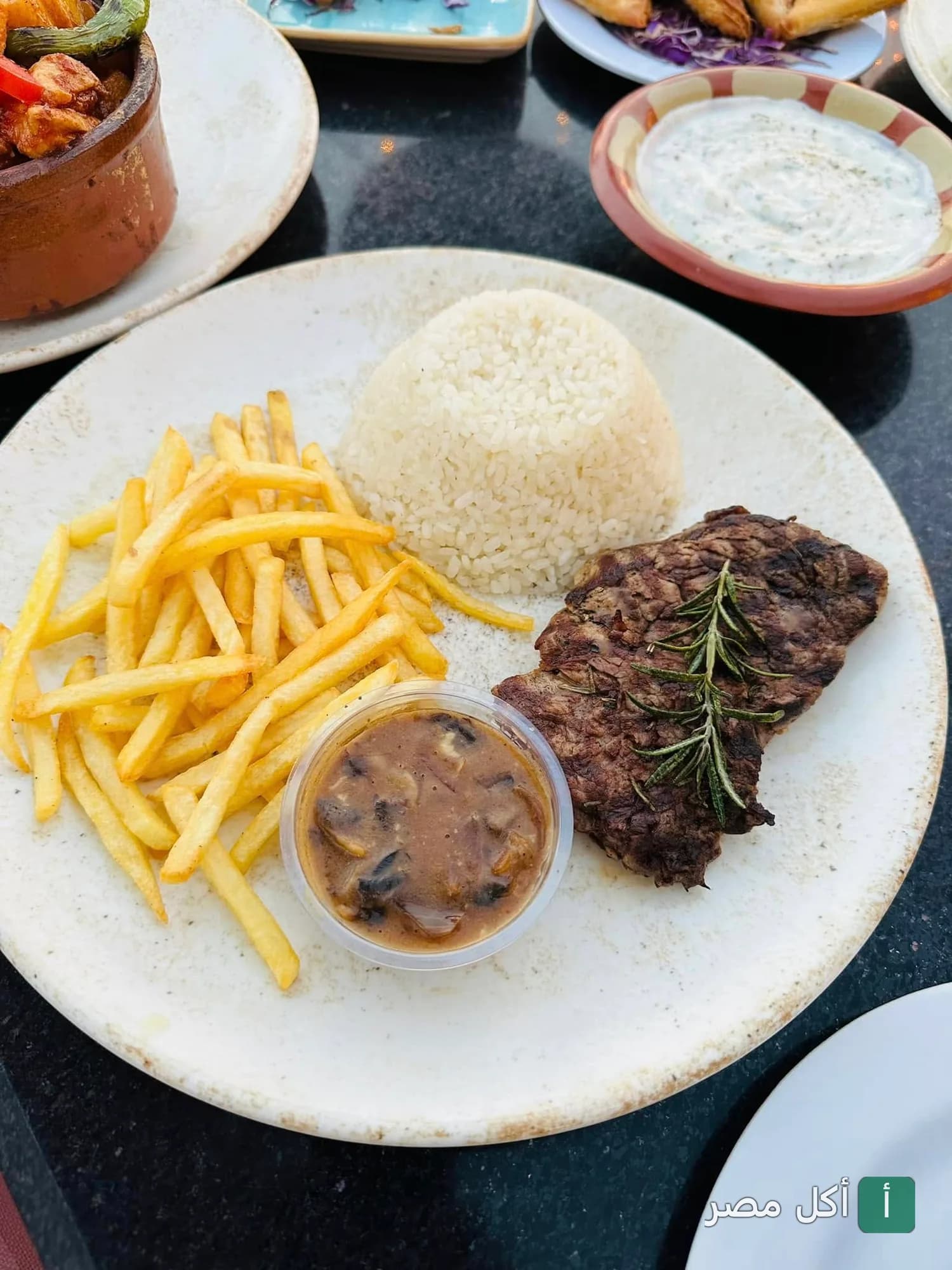 طبق ستيك مشوي مع أرز وبطاطس مقلية وصوص مشروم في مطعم فلوري بالشيخ زايد.