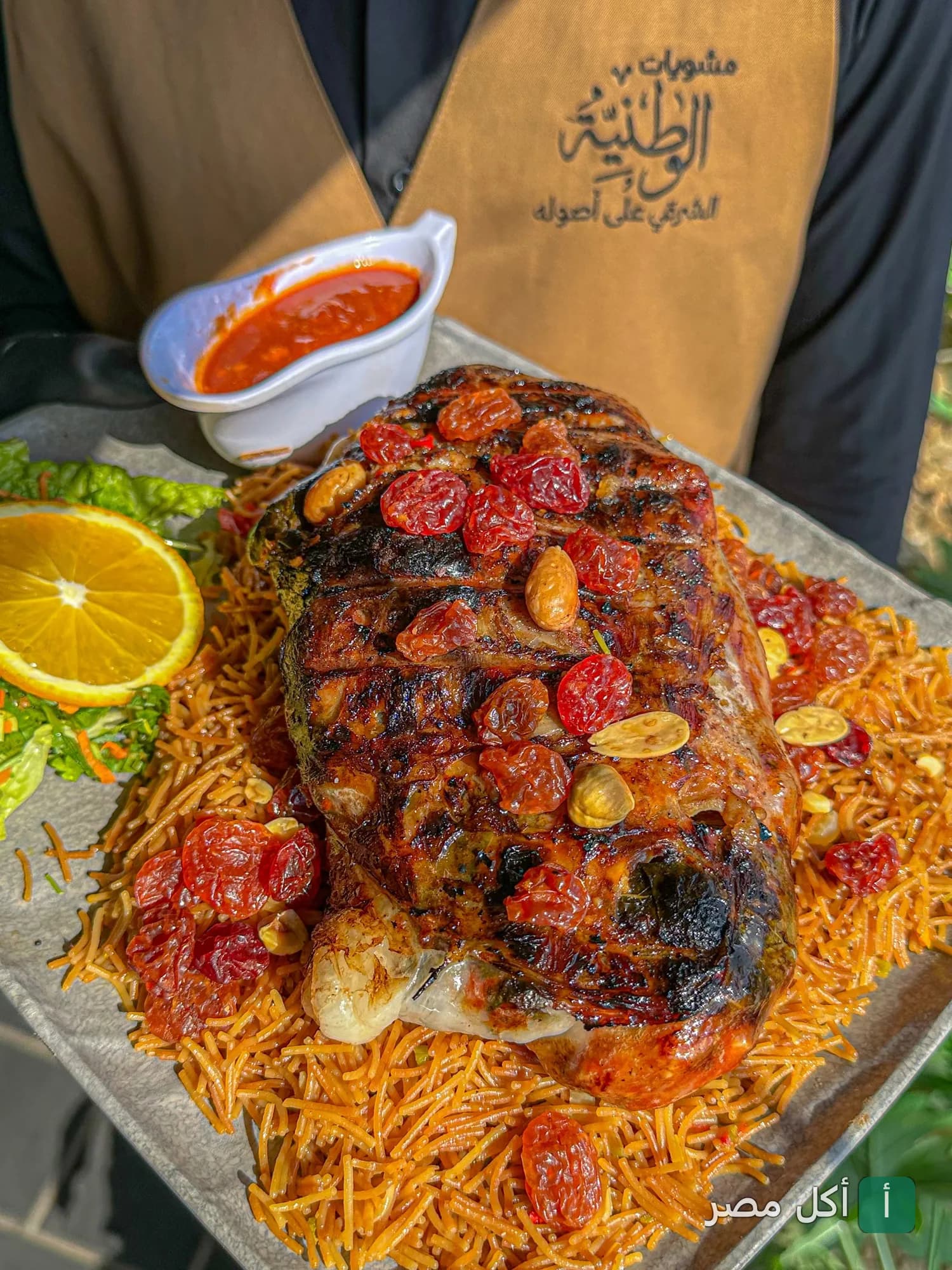 طبق مشويات من الوطنية للمشويات في الشيخ زايد، يقدم مع أرز بالشعيرية والمكسرات وصوص أحمر.
