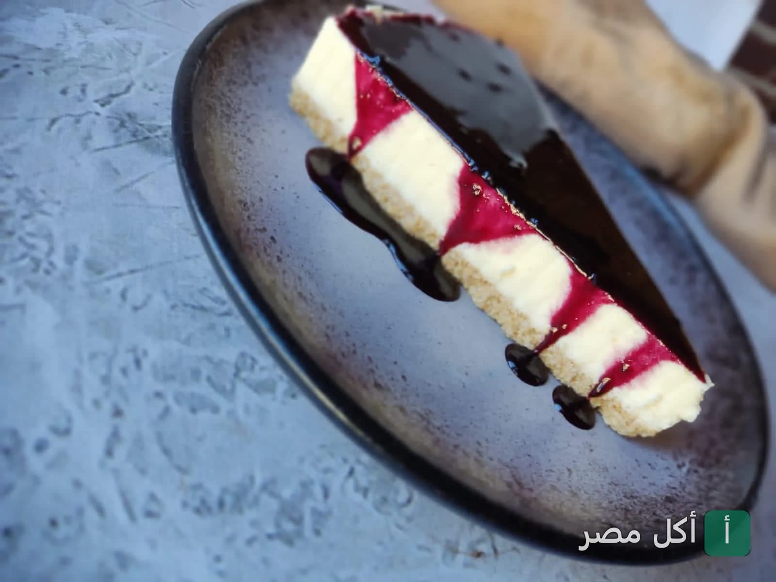قطعة تشيز كيك بصوص التوت على طبق في ديديز كافيه بالشيخ زايد