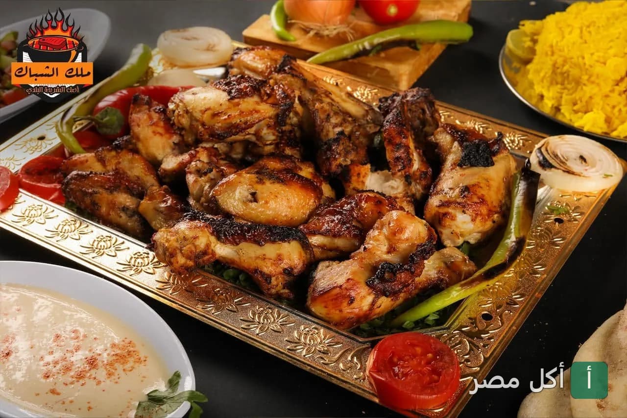 طبق مشاوي دجاج مشوي على الفحم مع أرز أصفر وطحينة من مطعم مشويات ملك الشباك في الشيخ زايد.