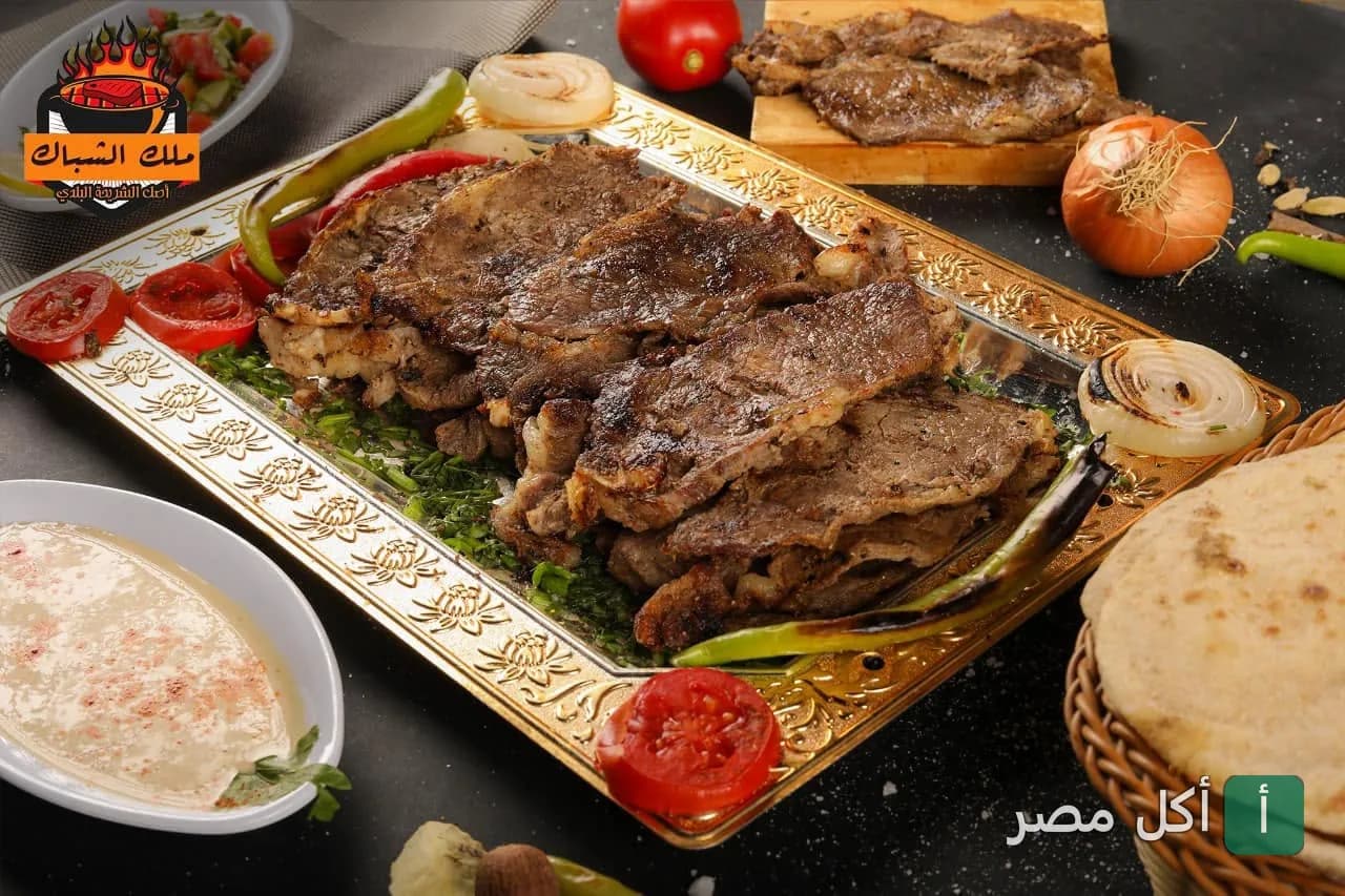 طبق مشاوي لحم بلدي مشوي على صينية ذهبية في مطعم مشويات ملك الشباك بالشيخ زايد