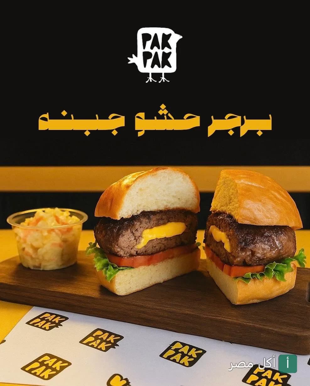 برجر محشو بالجبنة من مطعم باك باك في 15 مايو مع جانب من السلطة على لوح خشبي.