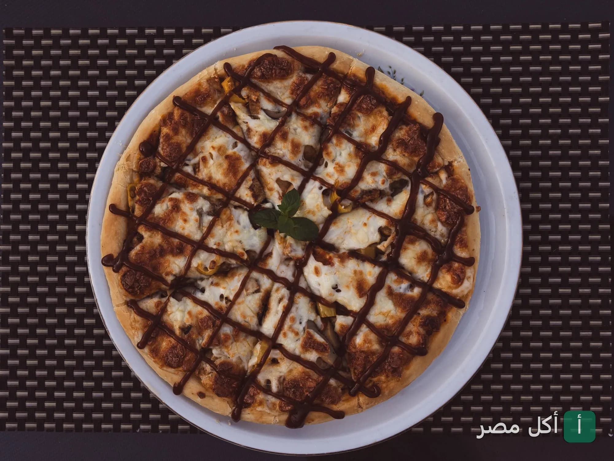 بيتزا مغطاة بالجبن وخطوط صوص الشوكولاتة من مطعم وكافيه بانوراما رمسيس في عابدين.
