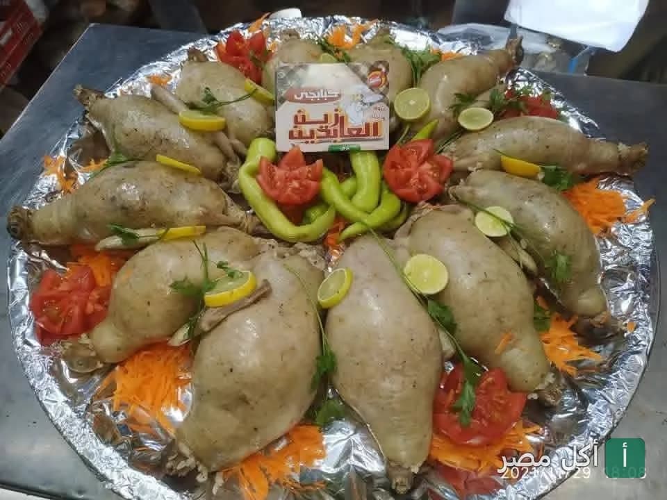 طبق حمام محشي مقدم من مطعم زين العابدين في عابدين مزين بالطماطم والفلفل والليمون.