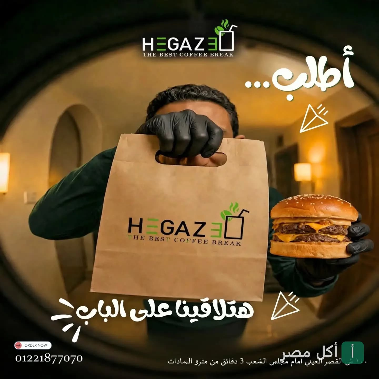 موظف مطعم وكوفي شوب حجازي في عابدين يحمل كيس الطلبات وشطيرة برجر.