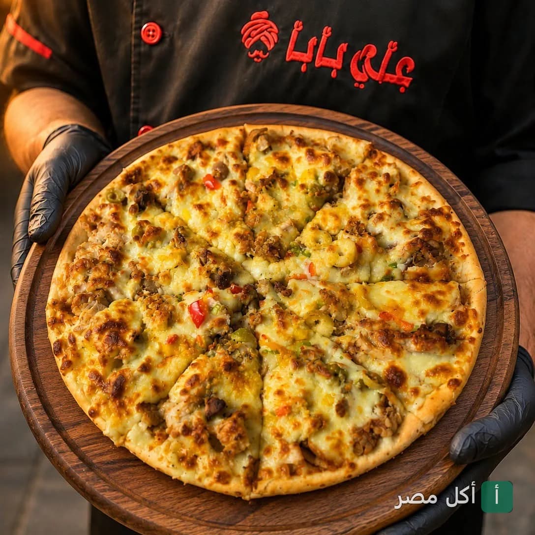 شيف يقدم بيتزا ساخنة على لوح خشبي في مطعم علي بابا بعابدين