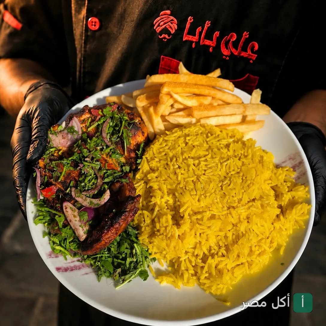 طبق مشويات من مطعم علي بابا في عابدين يضم أرز أصفر، دجاج مشوي بالأعشاب، وبطاطس محمرة.