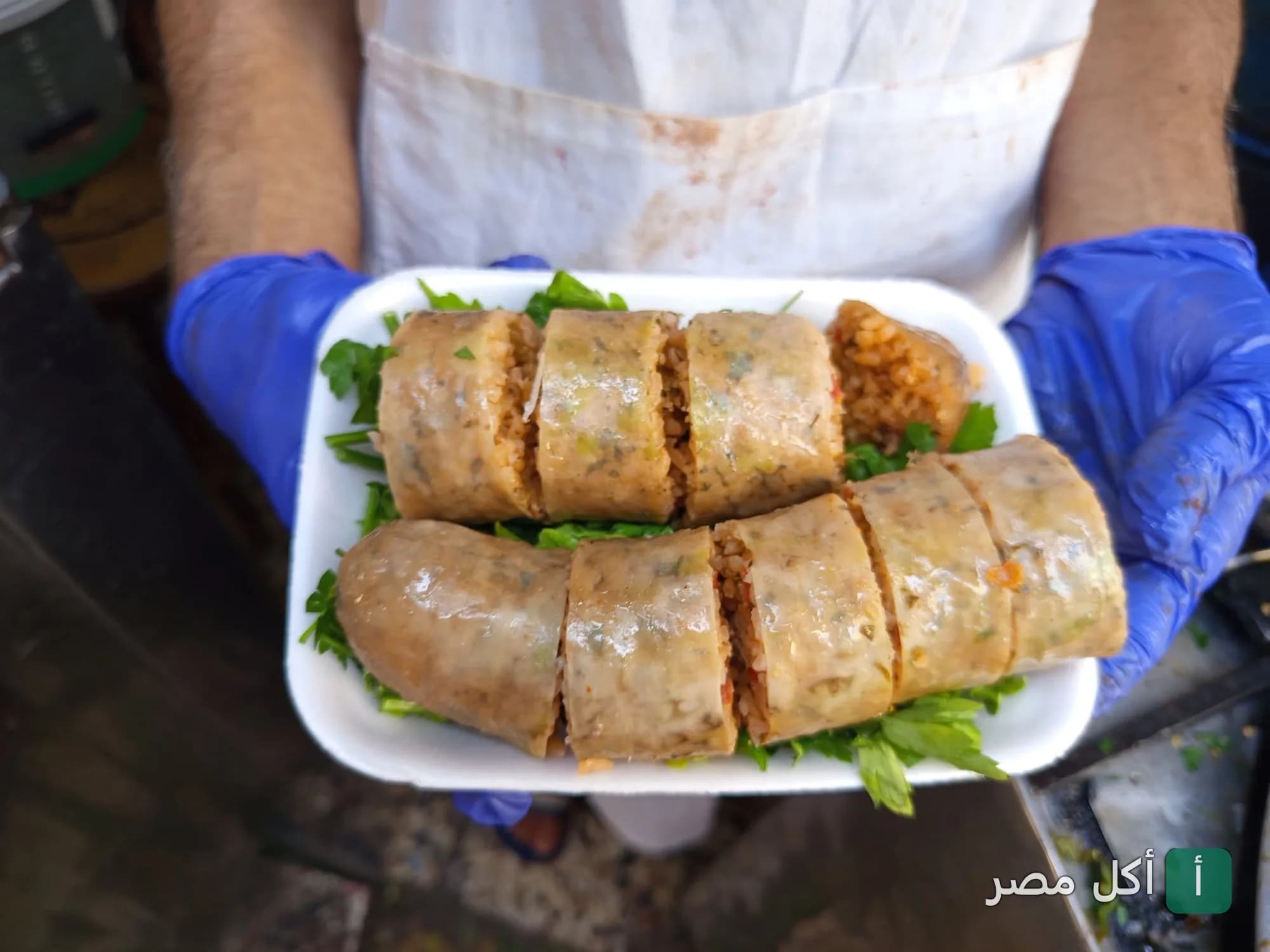 طبق ممبار محمر ومقطع يقدمه عامل في مسمط الشعب بعابدين.