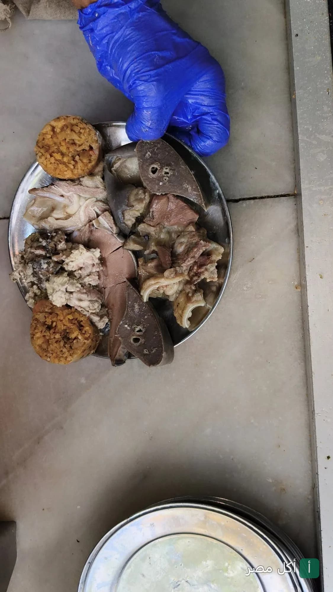 طبق مشكل من مسمط الشعب في عابدين يحتوي على قطع لحوم وممبار.