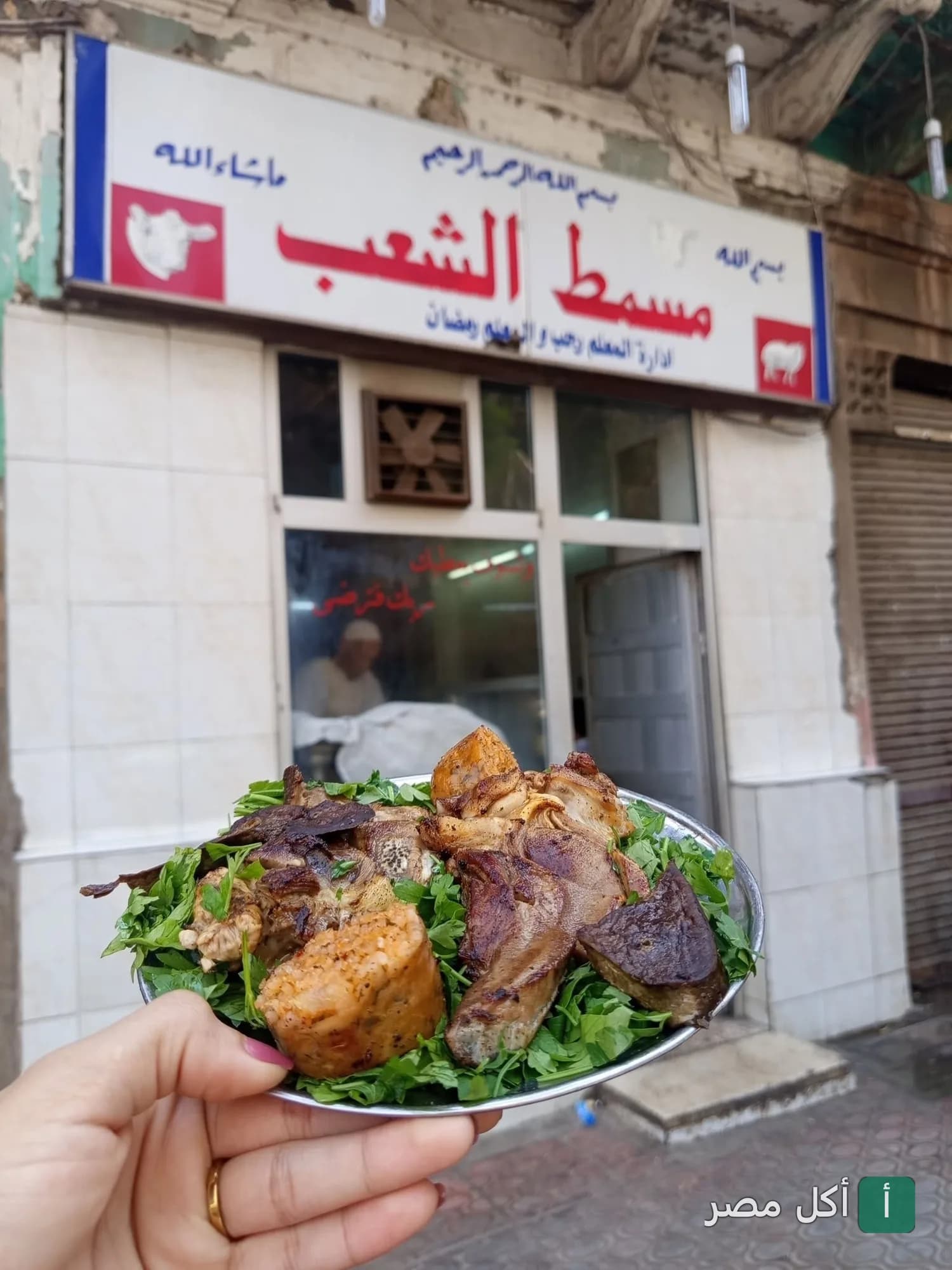 طبق مشويات متنوعة على بقدونس أمام واجهة مسمط الشعب في عابدين.
