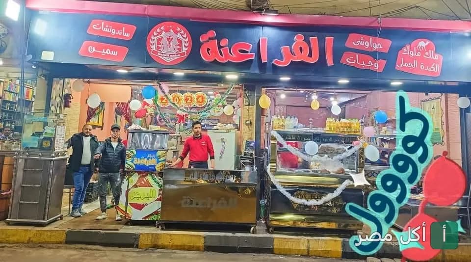 واجهة مطعم الفراعنة في عابدين مع لافتة كبيرة وموظفين يقفون أمام كاونترات الطعام.