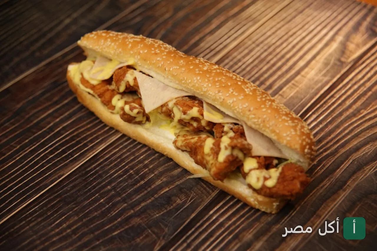 ساندوتش دجاج مقرمش مع صوص وجبنة في مطعم زنزانة بعين شمس
