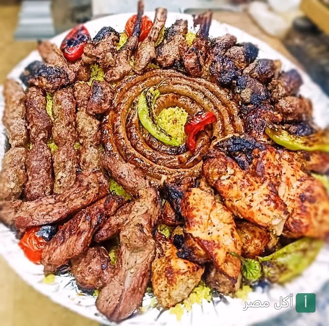 طبق مشويات مشكل من حاتي العمدة في عين شمس، يضم كفتة، ريش، وممبار محمر على فرشة أرز.