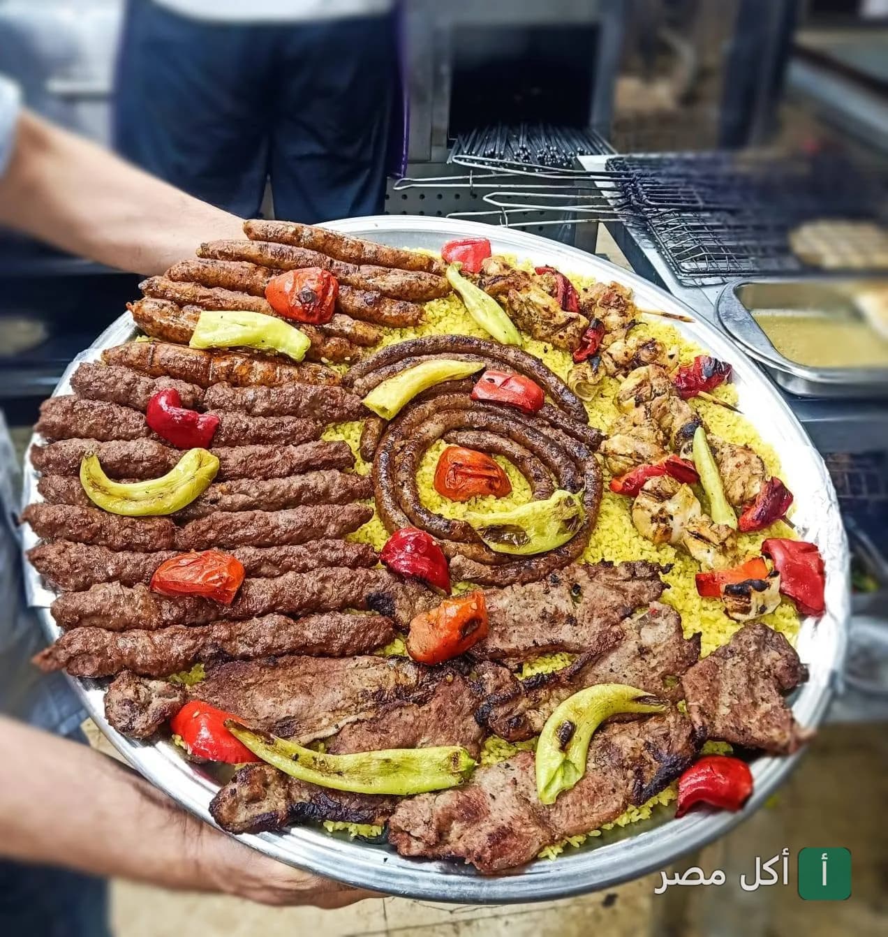 صينية مشويات مشكلة من حاتي العمدة في عين شمس، تضم كفتة وطرب وقطع لحم وشيش طاووق على أرز أصفر.