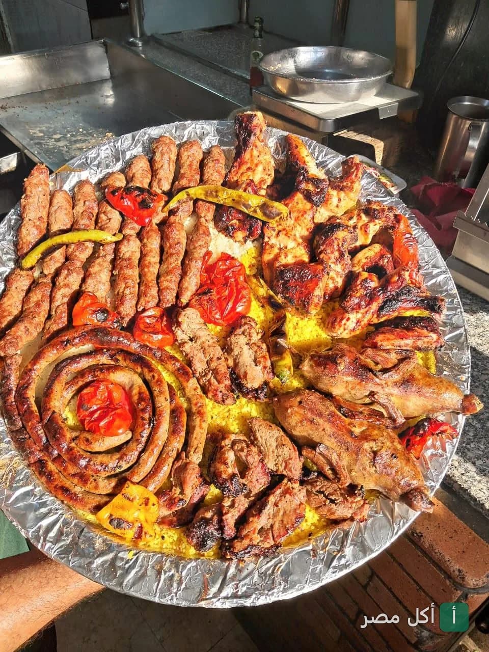 صينية مشويات مشكلة من حاتي العمدة في عين شمس تضم كفتة، طرب، سجق، وفراخ مشوية على أرز مبهر.