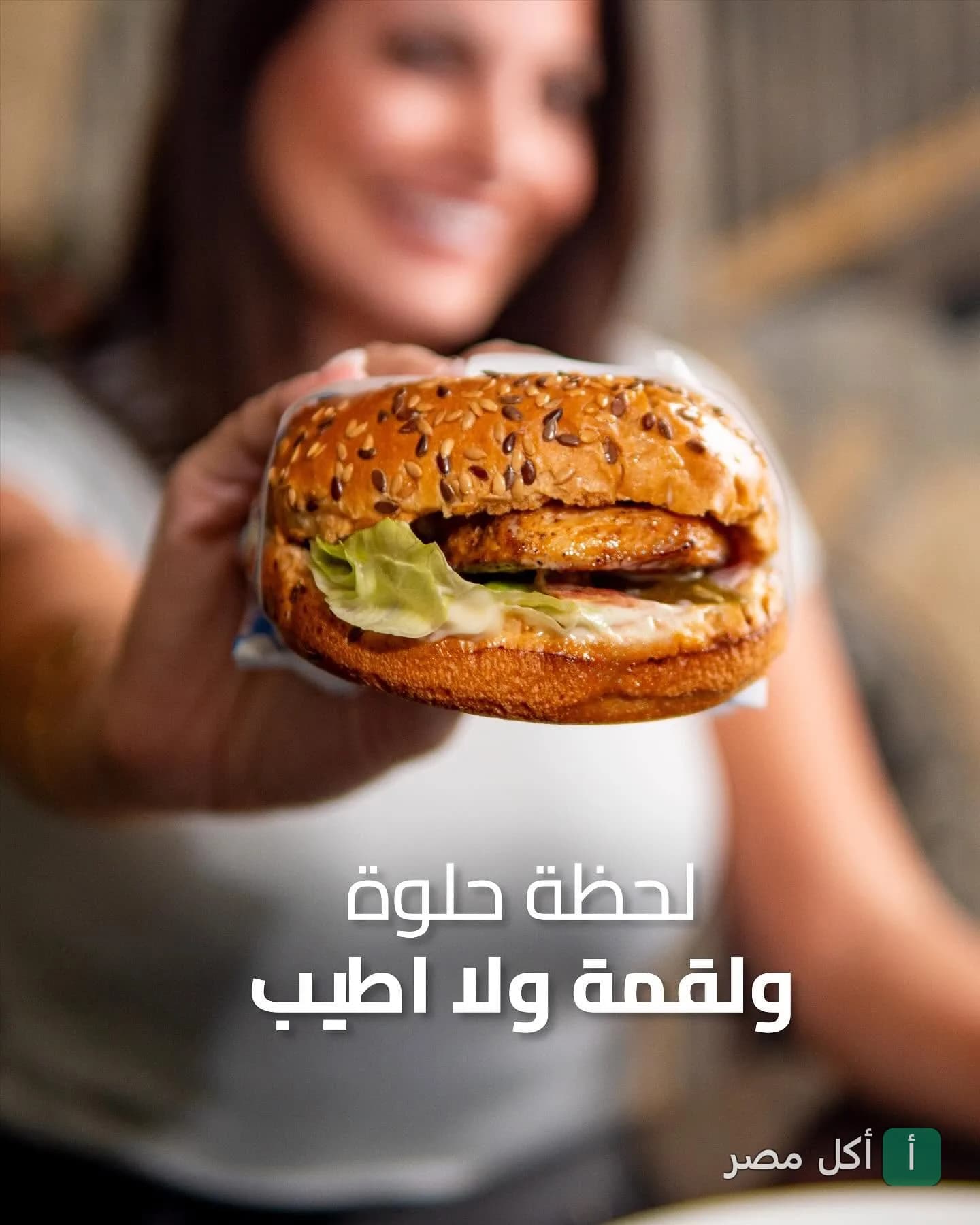 شخص يمسك ساندوتش برجر بخبز الحبوب من مطعم الطيب في عين شمس.