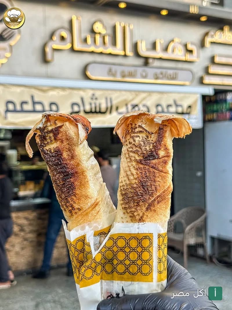 ساندوتشات شاورما محمرة أمام واجهة مطعم دهب الشام في عين شمس.